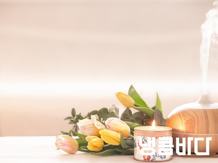 aromatic-oil-diffuser-lamp-on-the-table-on-a-blurred-background-with-a-beautiful-spring-bouquet-of-tulips-and-burning-candle.jpg